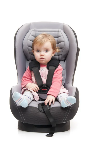 Girl sitting on child's car seat — Stock Photo, Image