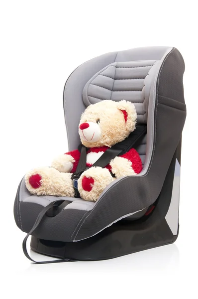 Medvídek sedí na dětské autosedačky — Stock fotografie