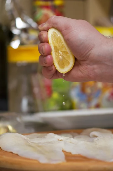 Squeezing lemon juice on fish fillets — Stock Photo, Image