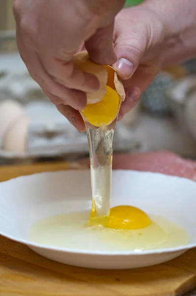 Мужчина разбивает куриное яйцо — стоковое фото