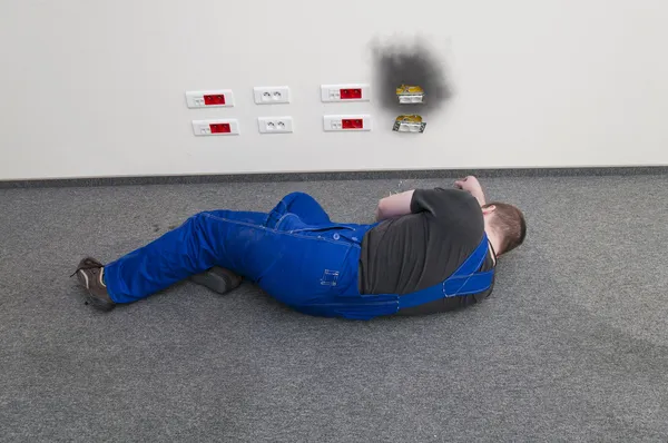 Mann am Boden liegend mit Elektroschocker Stockbild
