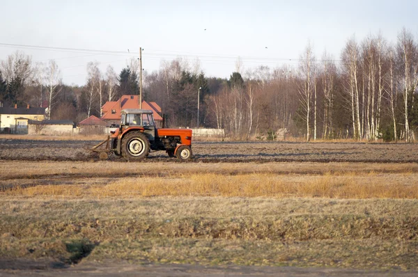 Oude tractor ploegt het veld — Stockfoto