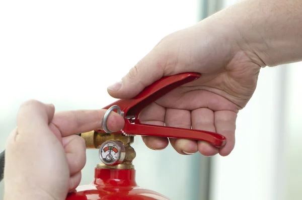 Mão pressiona o extintor de incêndio gatilho — Fotografia de Stock