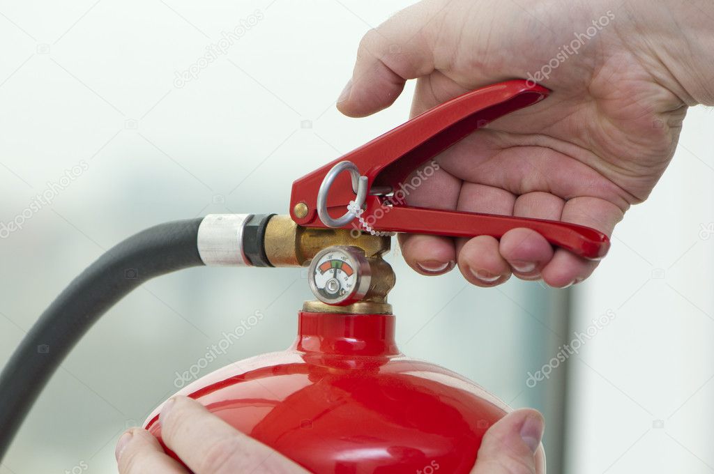 Рука нажимает на триггер огнетушитель — стоковое фото