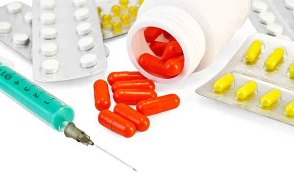 Capsule rouge avec des médicaments et une seringue — Photo