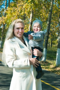 The young woman with the son on walk clipart