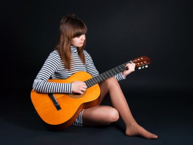 Girl with a guitar on a black background clipart