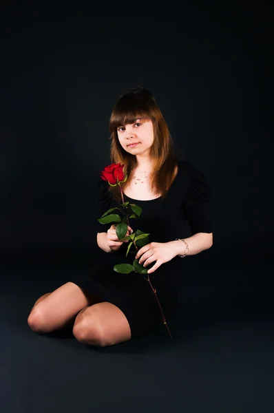 Девушка с розой на черном фоне — стоковое фото