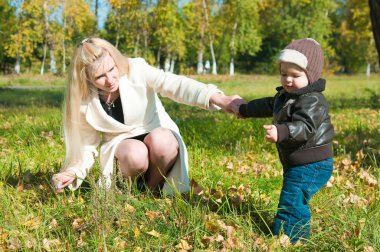 The young woman with the son on walk clipart