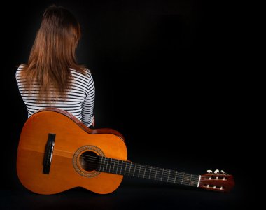 bir gitar üzerinde siyah bir arka plan ile kız