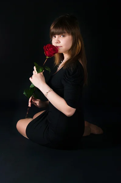Девушка с розой на черном фоне — стоковое фото
