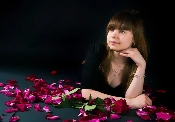 Chica con una rosa sobre un fondo negro —  Fotos de Stock
