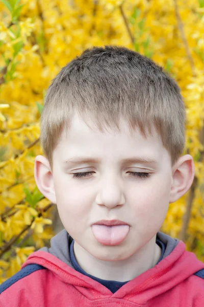 Портрет улыбающегося мальчика в весеннем саду . — стоковое фото