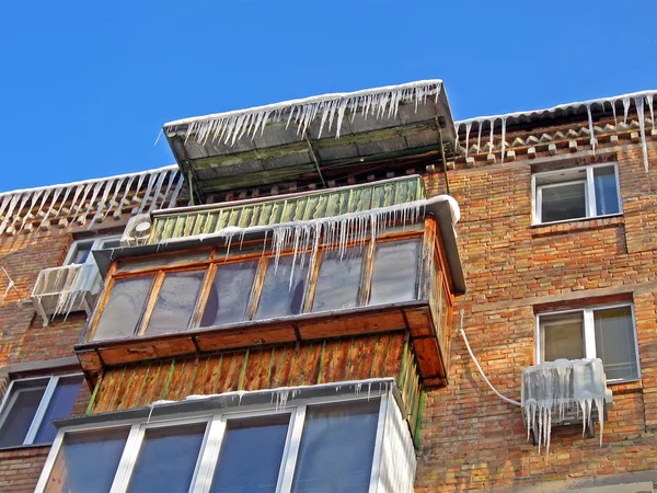 季節の詳細、建物の屋根の上の冬つららヒープ. — ストック写真