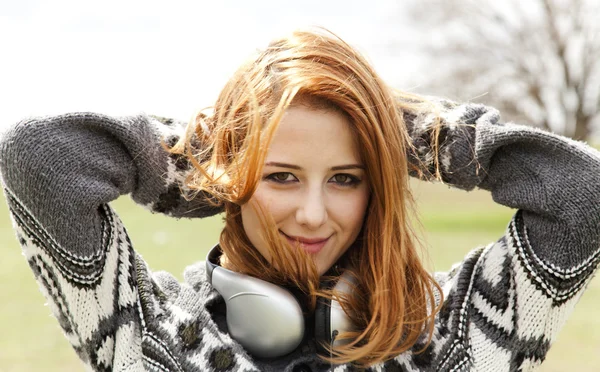 Menina de moda jovem com fones de ouvido na primavera ao ar livre . — Fotografia de Stock