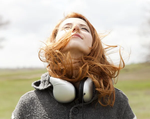 Chica de moda joven con auriculares en primavera al aire libre . — Foto de Stock