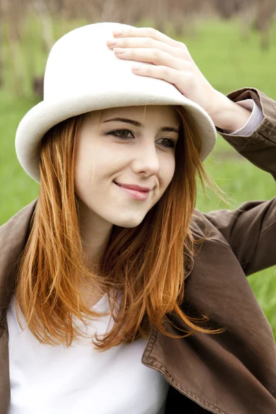 Muchacha de moda joven en sombrero blanco en verde hierba de primavera . — Foto de Stock