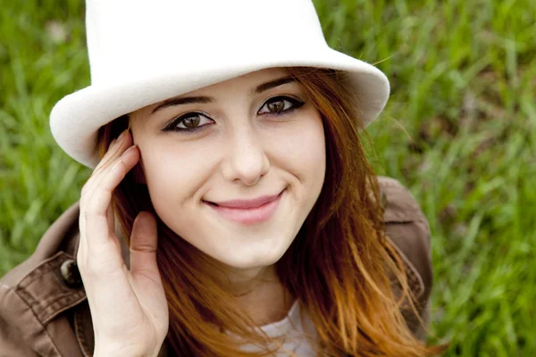 Young fashion girl in white hat at green spring grass. — Stock Photo, Image