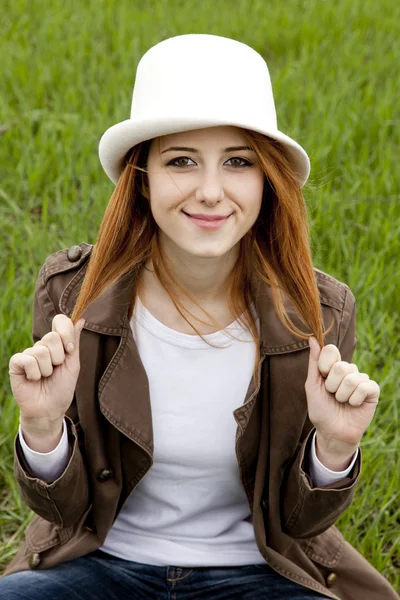 Menina de moda jovem em chapéu branco na grama de primavera verde . — Fotografia de Stock
