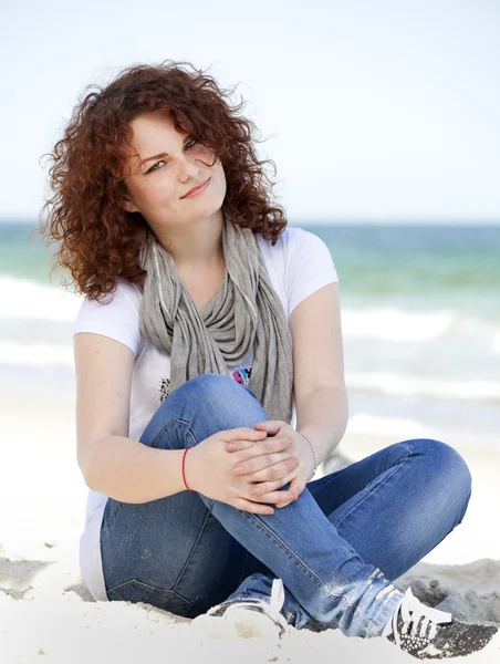 Divertente ragazza adolescente seduta sulla sabbia in spiaggia . — Foto Stock
