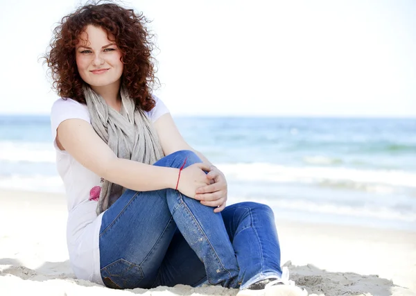 Rolig tonåring flicka sitter på sanden på stranden. — Stockfoto