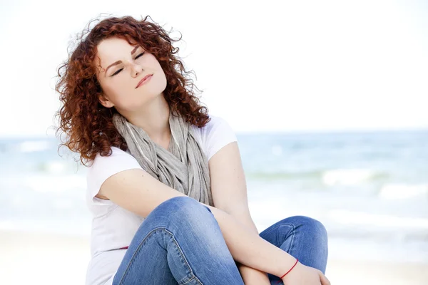Funny teen girl sitting on the sand at the beach. — Stock Photo, Image