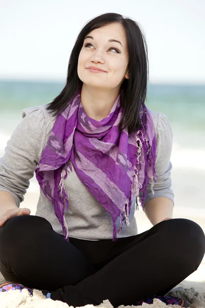 Divertido adolescente chica sentada en la arena en la playa . — Foto de Stock