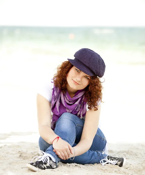 浜の砂の上に座って面白いの十代の少女. — ストック写真