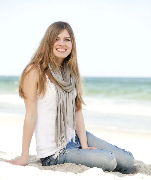 Divertente ragazza adolescente seduta sulla sabbia in spiaggia . — Foto Stock
