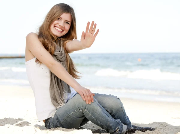 Divertido adolescente chica sentada en la arena en la playa . —  Fotos de Stock