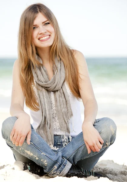 Divertido adolescente chica sentada en la arena en la playa . — Foto de Stock