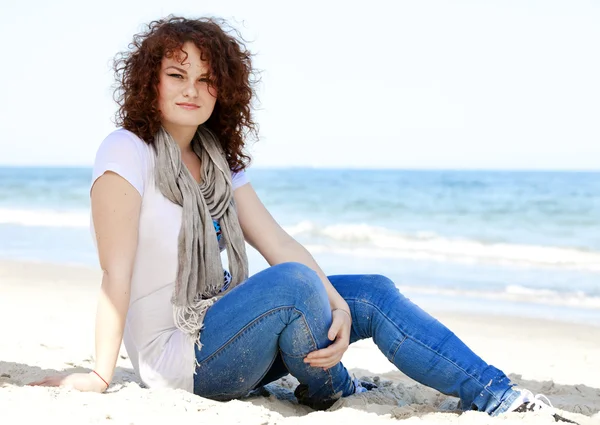 搞笑十几岁的女孩坐在海边的沙滩上. — 图库照片