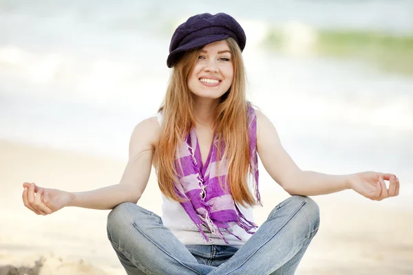 浜の砂の上に座って面白いの十代の少女. — ストック写真
