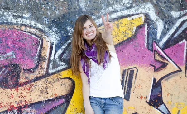 Stil tonåring flicka nära graffiti wall. — Stockfoto