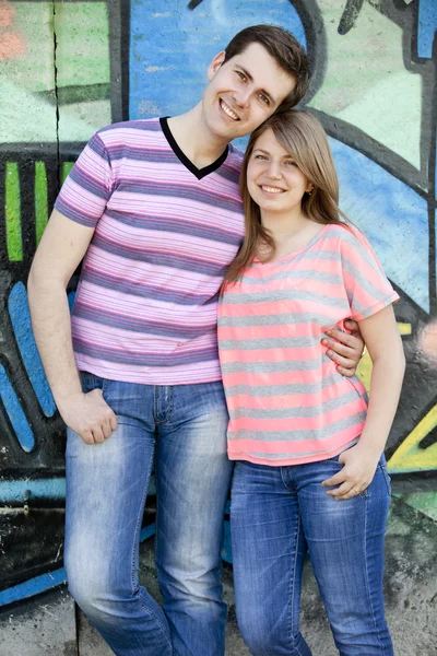 Νεαρό ζευγάρι κοντά γκράφιτι φόντο. — Φωτογραφία Αρχείου
