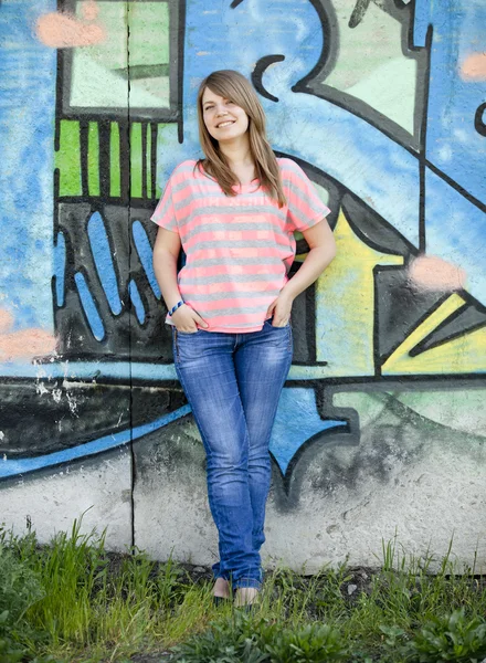Styl dziewczyna w pobliżu graffiti ściany. — Zdjęcie stockowe