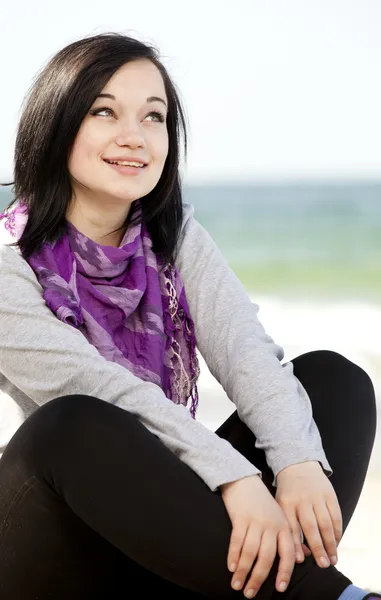Engraçado adolescente menina sentado na areia na praia . — Fotografia de Stock