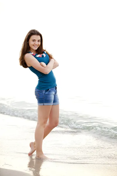 Brunett flicka på stranden i soluppgång. — Stockfoto