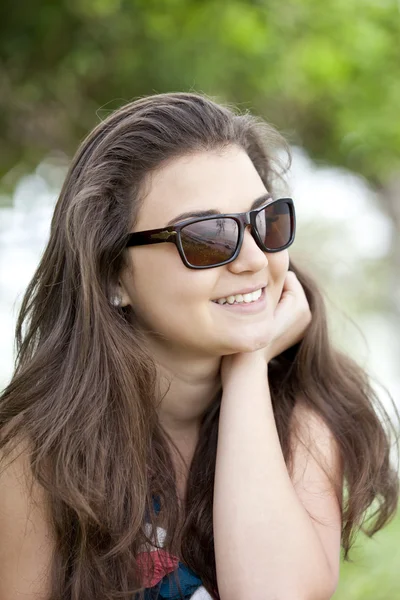 Brünettes Mädchen mit Sonnenbrille im Sommerpark. — Stockfoto