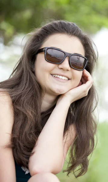 Брюнетка дівчина в сонцезахисні окуляри на літній парк. — стокове фото