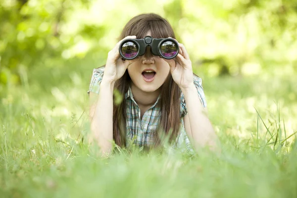 Teenie-Mädchen mit Fernglas im grünen Gras — Stockfoto