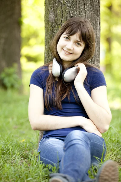 Молода дівчина моди з навушниками на зеленій весняній траві . — стокове фото