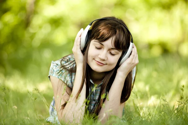 Młoda dziewczyna moda ze słuchawkami w zielonej trawie wiosna. Obrazy Stockowe bez tantiem