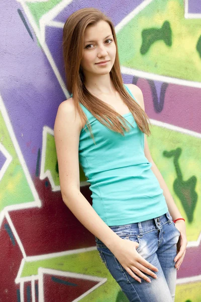 Stil tonåring flicka nära graffiti bakgrund. — Stockfoto