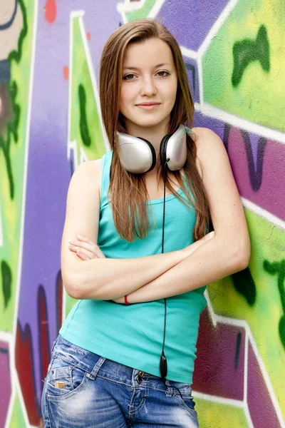 Estilo chica adolescente con gafas de sol cerca de fondo de graffiti . — Foto de Stock