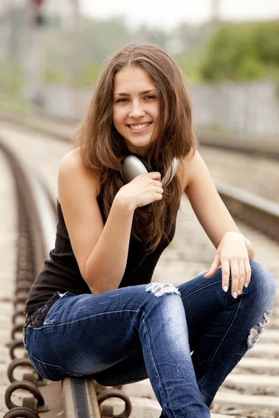 Adolescente avec écouteurs sur les chemins de fer . — Photo