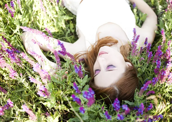 红发女孩在紫色的花. — 图库照片