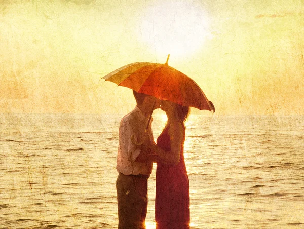 在日落海滩在接吻的情侣. — 图库照片