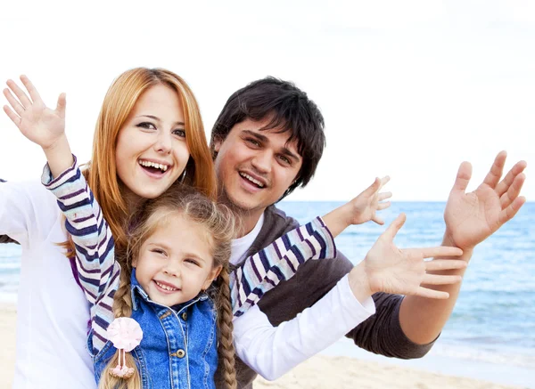 Młoda rodzina na plaży jesienią. — Zdjęcie stockowe