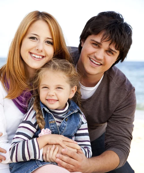 Giovane famiglia in spiaggia in autunno . — Foto Stock